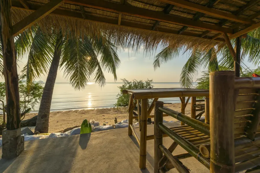 Avila Reizen Indonesie Tropical island hut on beach at sunset
