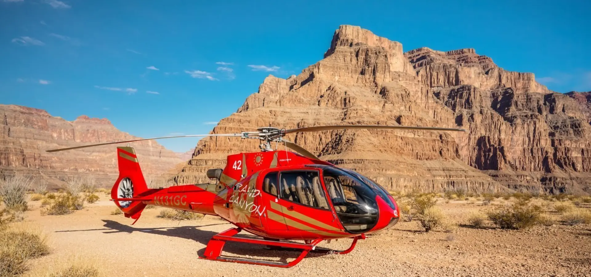 Rs14895 dsc02831 red ec130 helicopter landed bottom of grand canyon west new bluff site landing clear blue skies